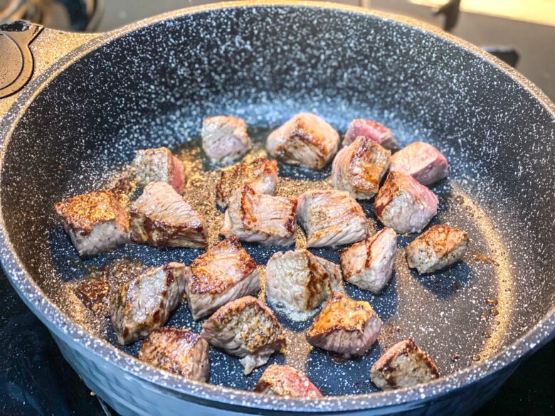 Sear steak in a pan for beef stroganoff. 