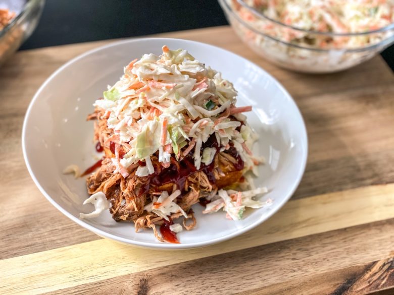 Corn bread, pulled pork, topped with coleslaw in a bowl. 