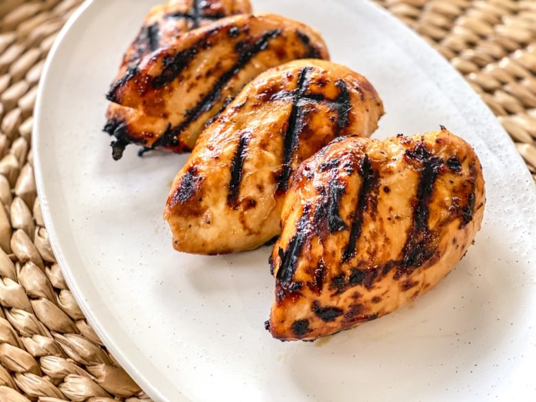 Chicken breasts with mustard and brown sugar marinade on a white plate. 