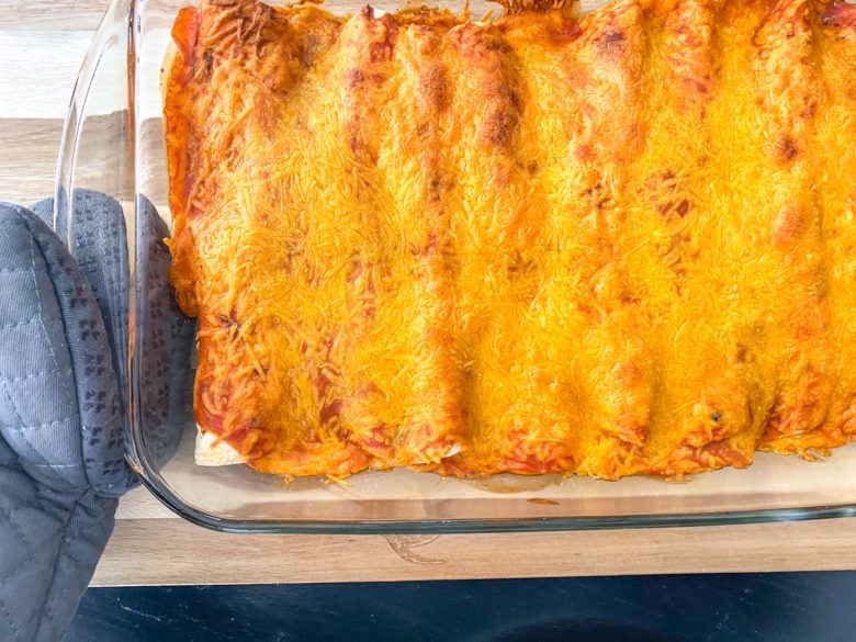 Enchiladas with melted cheese in a glass pan. 