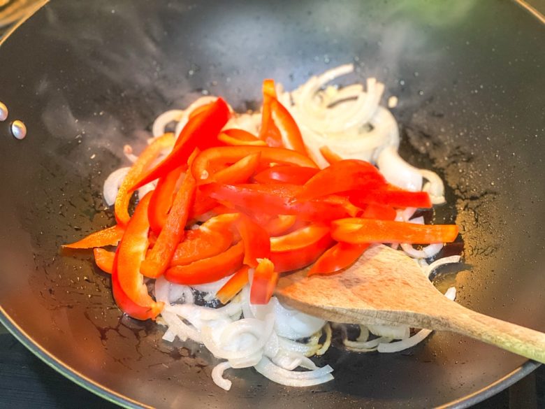 Sauté onions and red peppers in a large wok. 