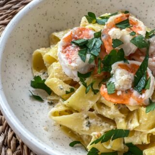 Boursin cheese alfredo pasta with shrimp and parsley in a bowl.