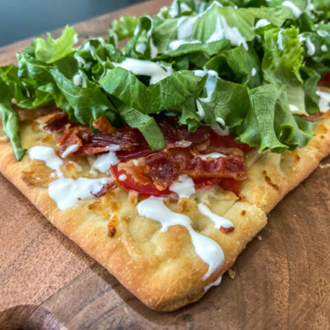 BLT flatbread pizza on a cutting board.