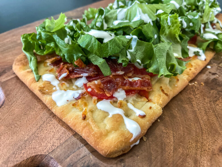 BLT flatbread pizza on a cutting board. 