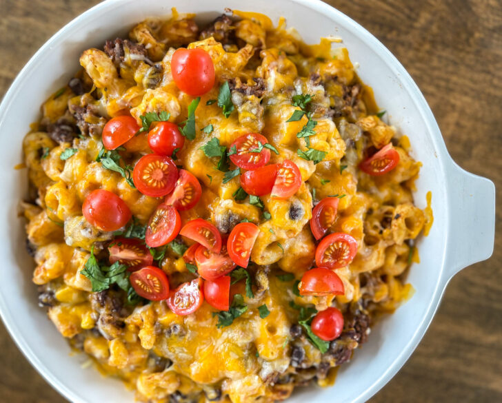 Taco pasta casserole baked in a casserole dish with melted cheese.